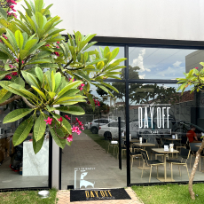 Fachada em vidro da Unidade II do Day Off em Rio Preto com uma folhagem a esquerda