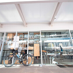 Unidade 1 Rio Preto | Day Off Café - Duo JK Fachada de vidro da unidade do Day Off na JK em Rio Preto, com uma bicicleta em frente